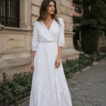 Rochie lungă albă, cu decolteu petrecut și fustă în trepte